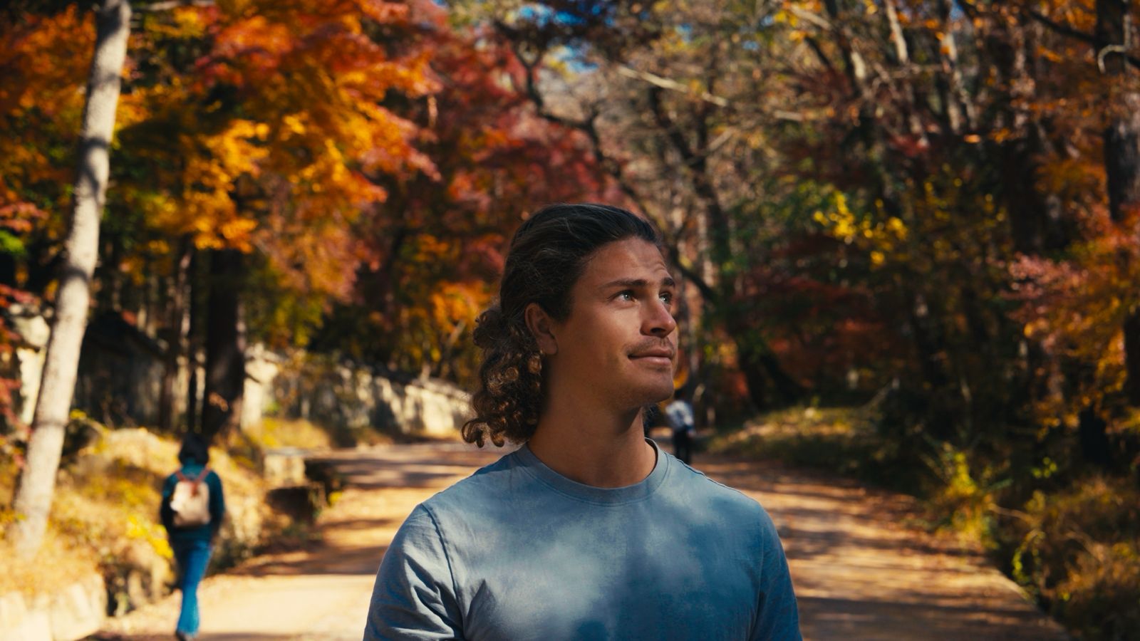 Dr. Sam Soete walking a forest path in autumn